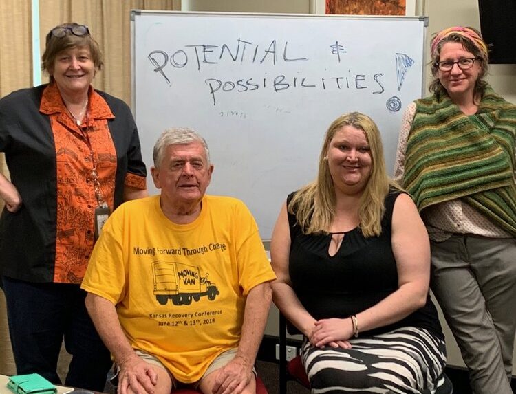 4 people in front of whiteboard that says Potential Possibilities